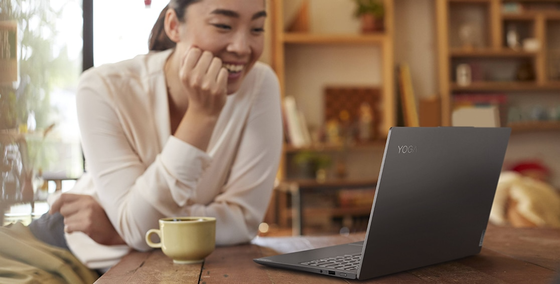 Personne assise à une table regardant un ordinateur portable Lenovo Yoga Slim 7i Pro Gen 7