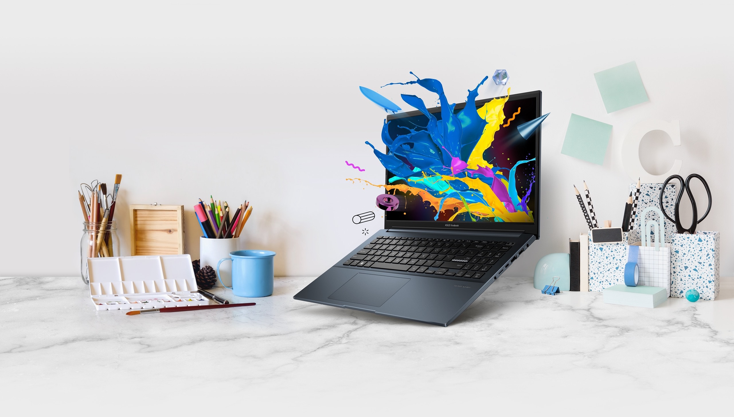 Vivobook Pro 15 OLED flottant au-dessus d'un bureau avec du matériel d'artiste et de la papeterie. Un graphique coloré sort de l'écran.