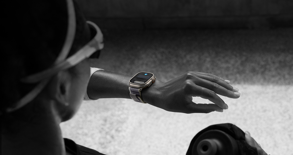 Une personne qui court regarde une Apple Watch Ultra 2 à son poignet gauche et effectue le geste toucher deux fois avec l'index et le pouce de sa main gauche
